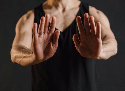 Person's hands in a meditative gesture during exercise.